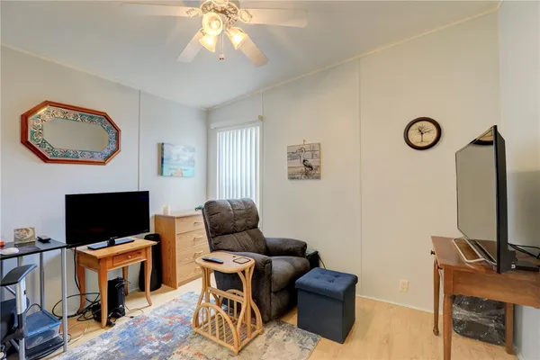 a living room with furniture a flat screen tv and a window