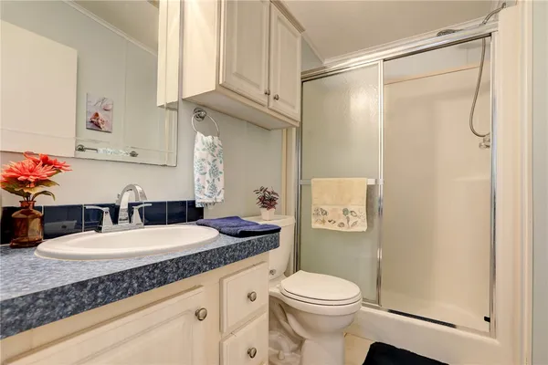 a bathroom with a granite countertop sink toilet and shower