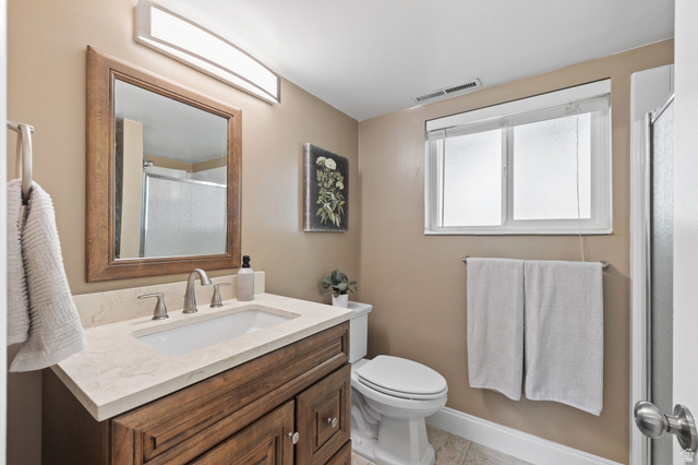 2370 Quail Run Circle East Sandy, UT 84093 - Photo 27 of 54 Bathroom featuring a wood-finish vanity with a light-toned countertop and an undermount sink