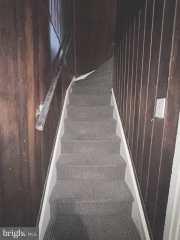a view of staircase with white walls and white door