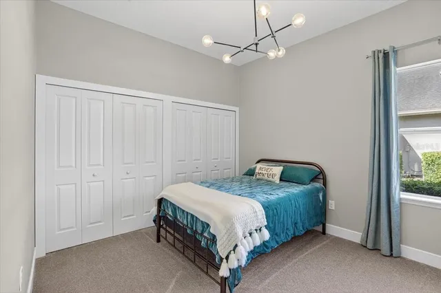a view of a brick house with a big yard and large trees