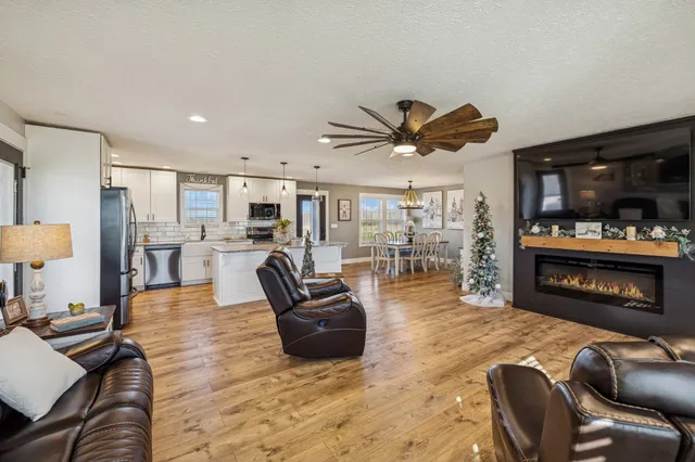 a living room with furniture and a flat screen tv with kitchen view