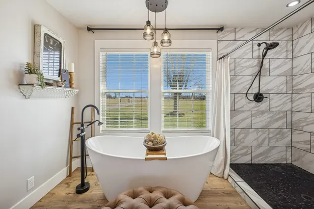 a white bath tub sitting in a bathroom next to a window