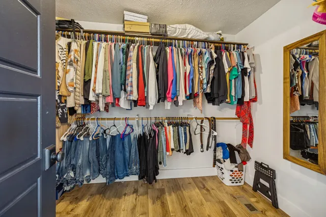 a view of walk in closet with clothes