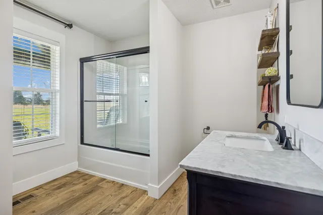 a bathroom with a granite countertop sink and a mirror