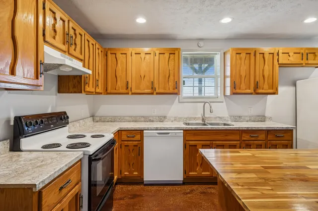 a kitchen with stainless steel appliances granite countertop a stove a sink and a microwave