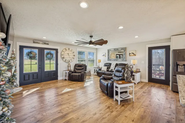 a living room with furniture a fireplace and a large window with wooden floor