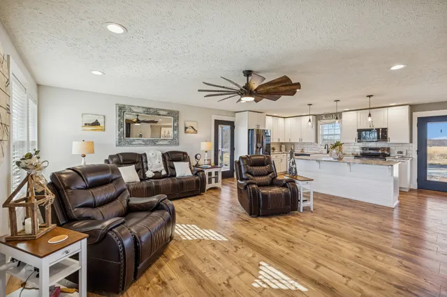a living room with furniture kitchen view and a window