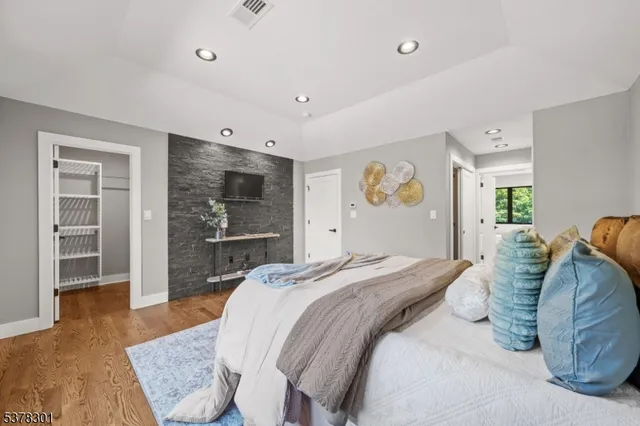 a spacious bedroom with a bed and a dresser