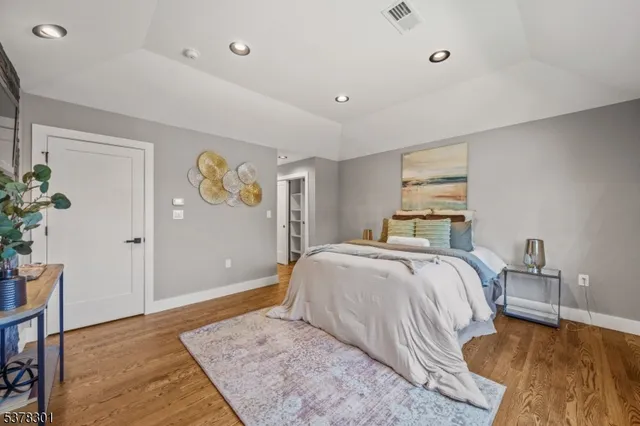 a bedroom with a large bed and wooden floor