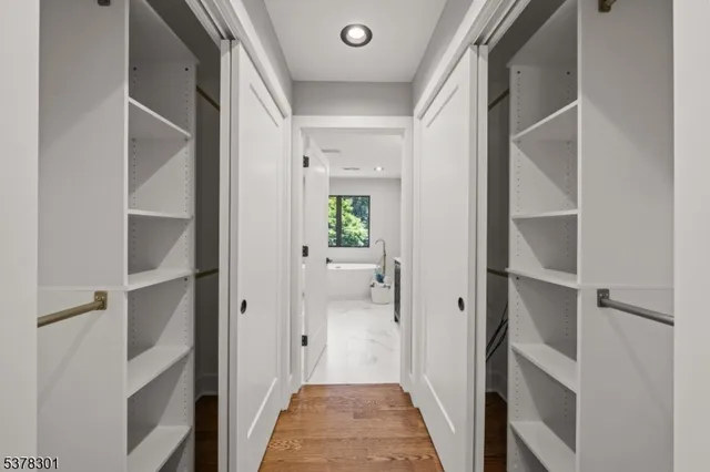 a view of a hallway with wooden floor and entryway