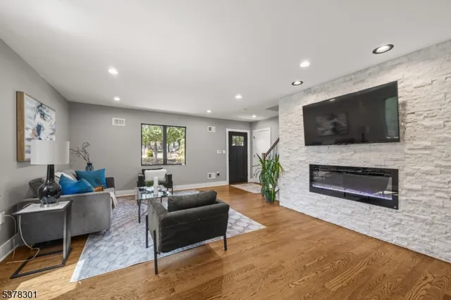 a living room with furniture a flat screen tv and a fireplace
