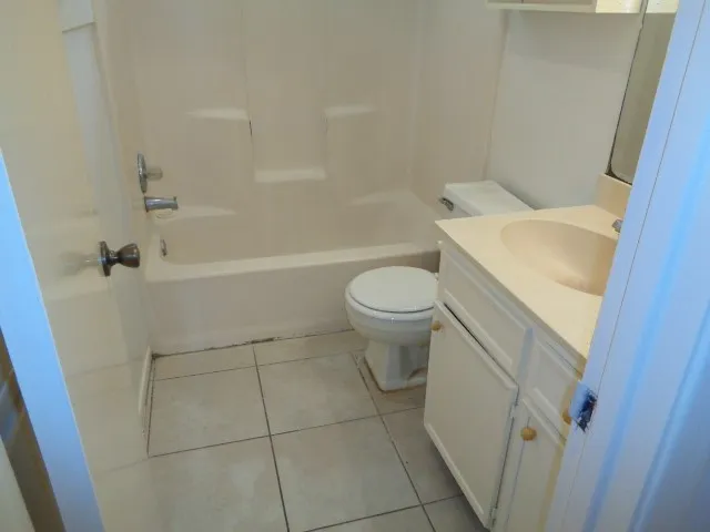 a white toilet sitting next to a bath tub