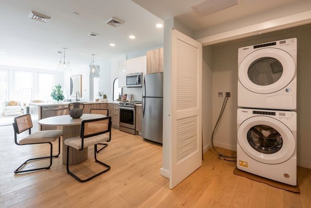 a living room with furniture a washer and dryer with kitchen view