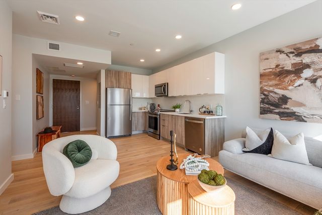 a living room with furniture and kitchen view
