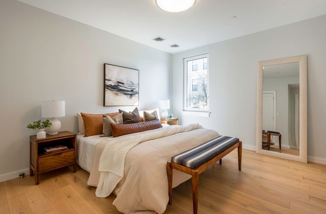 a bedroom with a bed and wooden floor