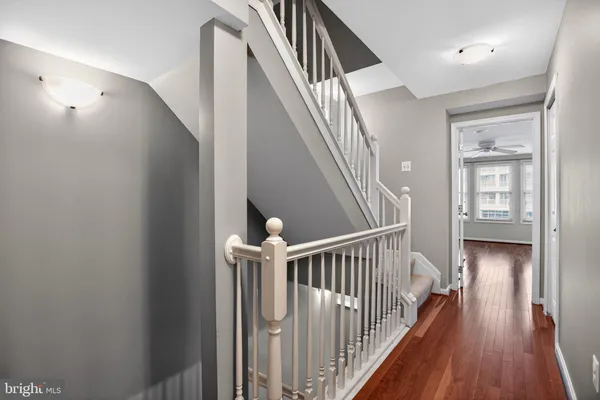 a view of a hallway with wooden floor and staircase