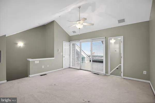 a view of an empty room with a ceiling fan