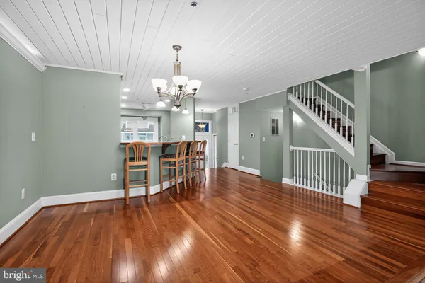 a view of a livingroom with wooden floor and stairs
