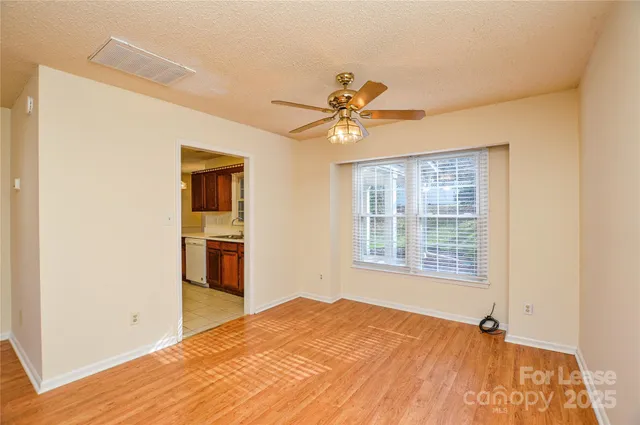 a view of an empty room with a fireplace and a window
