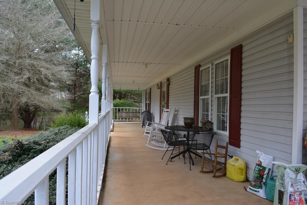 390 Mitchell Ridge Road Elkin, NC 28621 - Photo 2 of 20 Welcoming front porch runs the length of the house and is plenty wide! Also has concrete floor for durability!