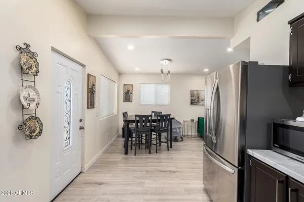 a kitchen with stainless steel appliances a refrigerator and a dining table