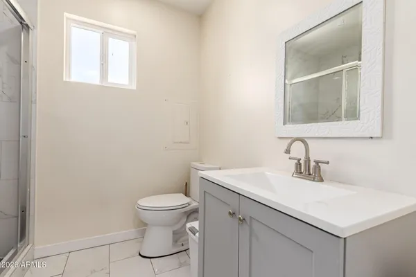 a bathroom with a sink a toilet and a mirror