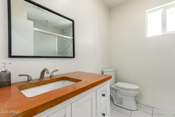 a bathroom with a sink a toilet and a mirror