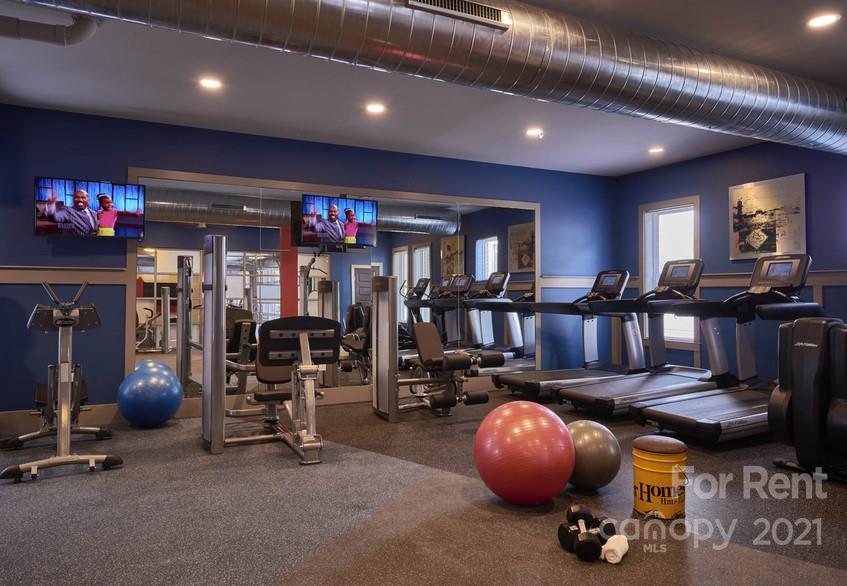 703 Rollerton Road Charlotte, NC 28205 - Photo 21 of 27 a room with gym equipment and a chandelier