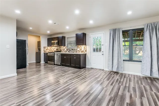 a view of kitchen with kitchen island wooden floor and refrigerator