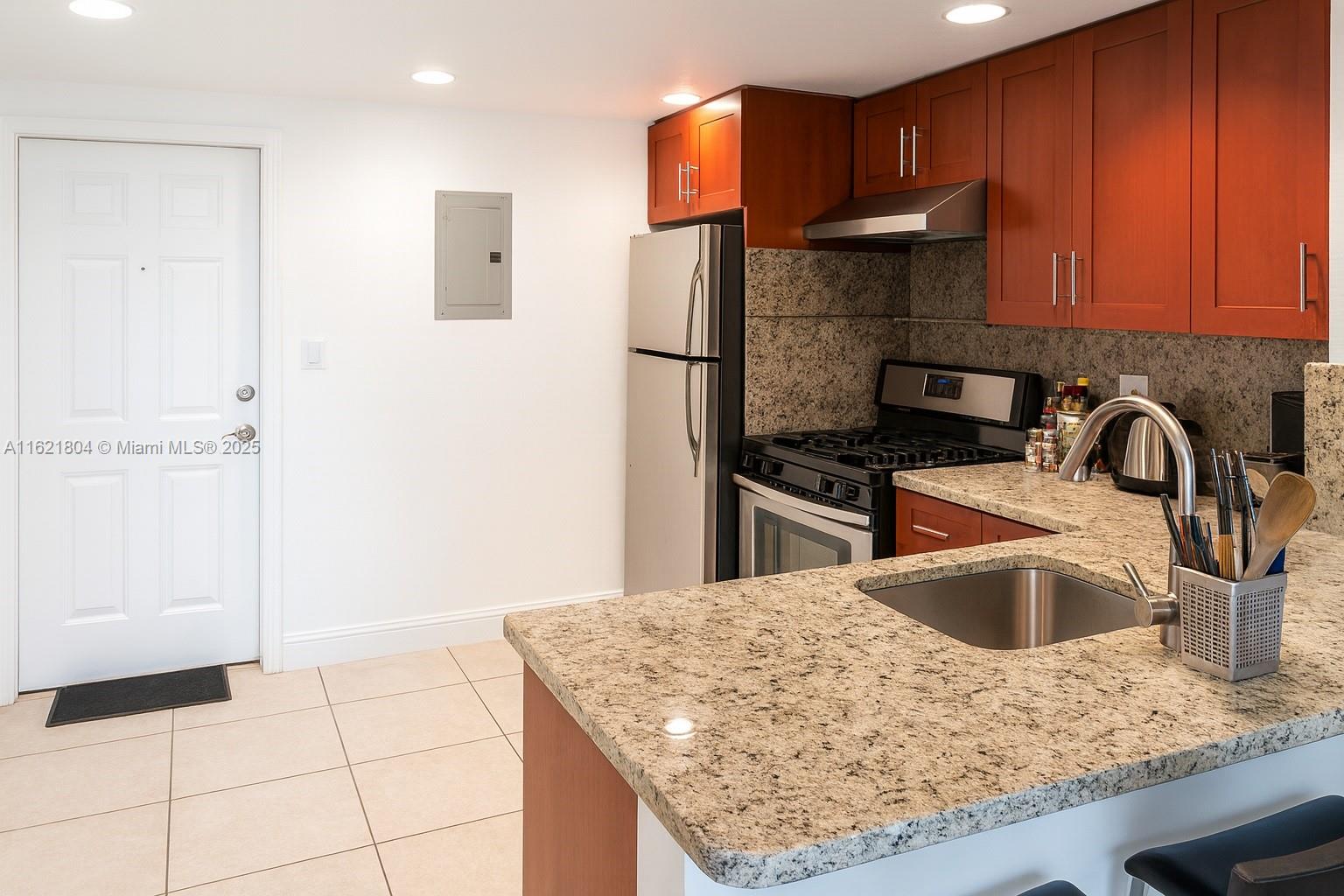 a kitchen with stainless steel appliances granite countertop a sink stove and refrigerator