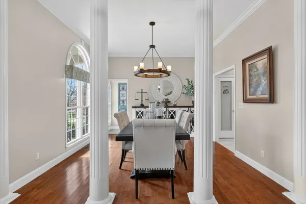 a view of a dining room with furniture a chandelier and wooden floor