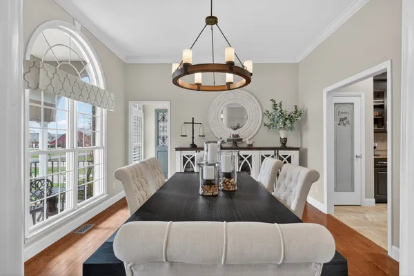 a dining room with furniture a chandelier and wooden floor
