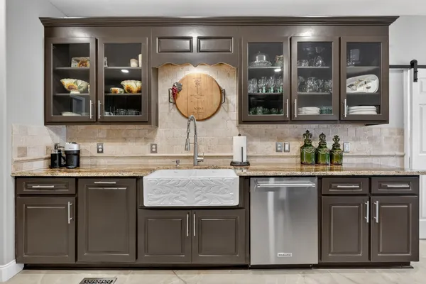 a kitchen with granite countertop a refrigerator and microwave