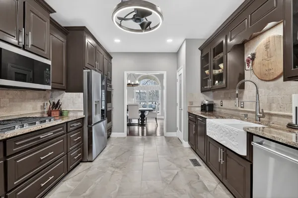 a kitchen with stainless steel appliances granite countertop a stove microwave and cabinets