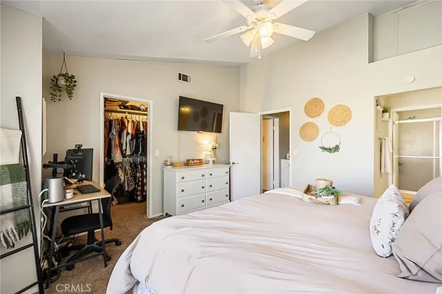 a bedroom with a bed dresser and flat screen tv
