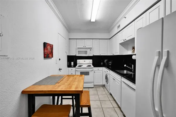 a kitchen with stainless steel appliances granite countertop a refrigerator a sink dishwasher a stove and white countertops with cabinets