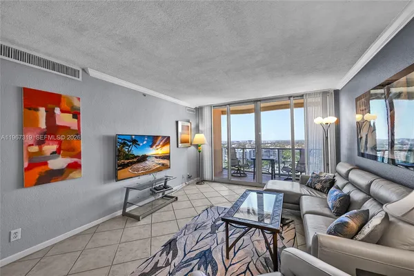 a living room with furniture a flat screen tv and a floor to ceiling window