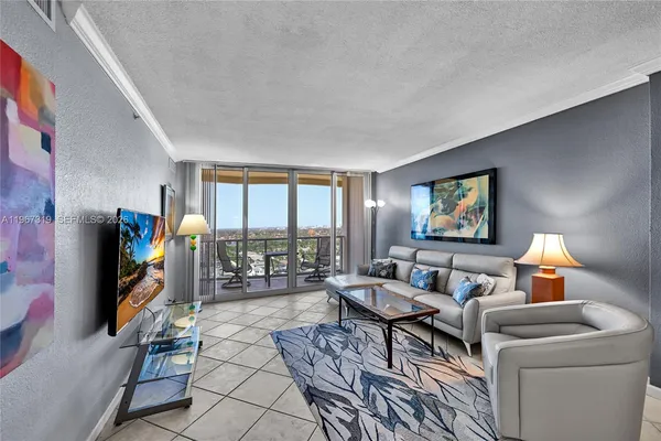 a living room with furniture a flat screen tv and a floor to ceiling window