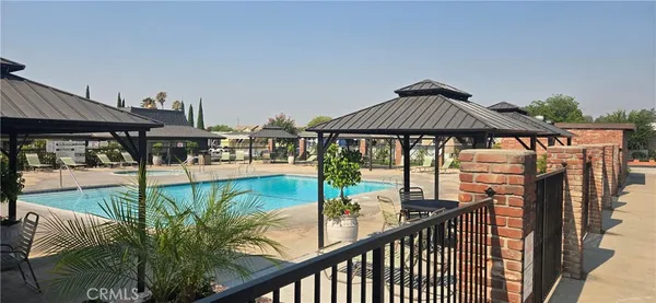 a view of a patio with lawn chairs under an umbrella