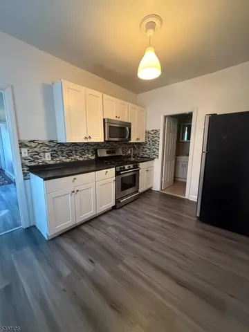a kitchen with stainless steel appliances granite countertop a stove and a refrigerator