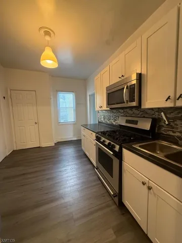 a kitchen with stainless steel appliances wooden cabinets and a stove top oven