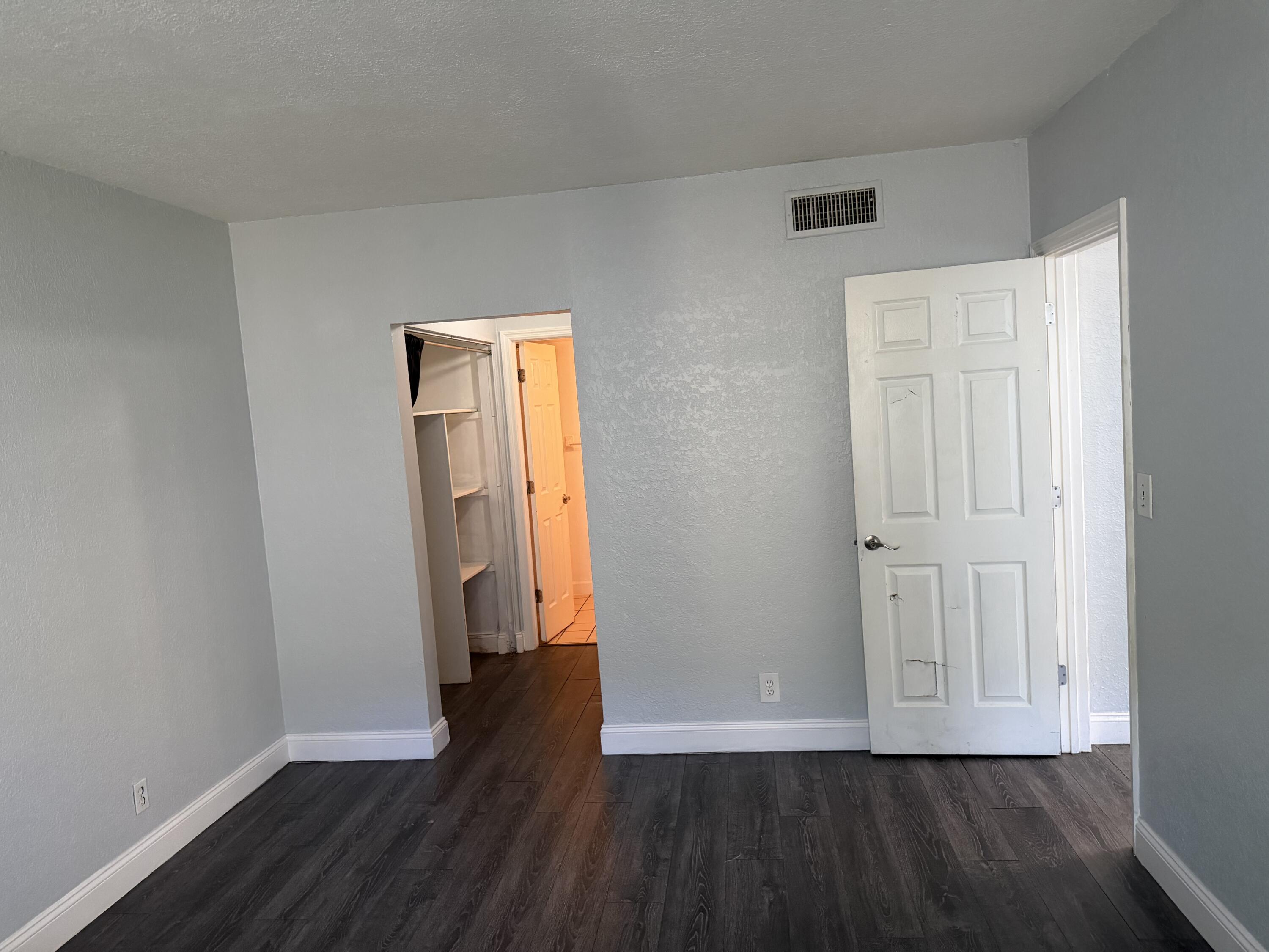 270 South Cypress Road, Unit 204 Pompano Beach, FL 33060 - Photo 7 of 14 an empty room with wooden floor and closet