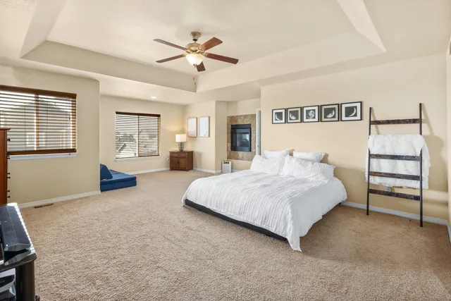 a spacious bedroom with a bed and ceiling fan