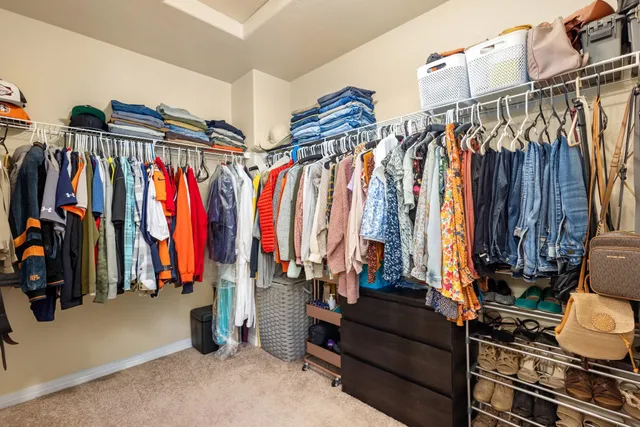 a view of walk in closet with clothes and shoes