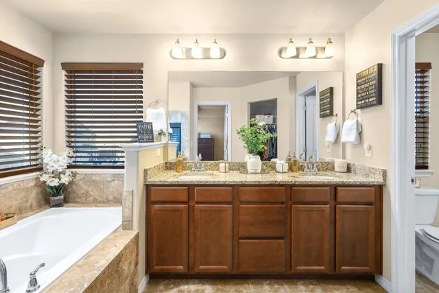 a bathroom with a granite countertop sink and a bathtub