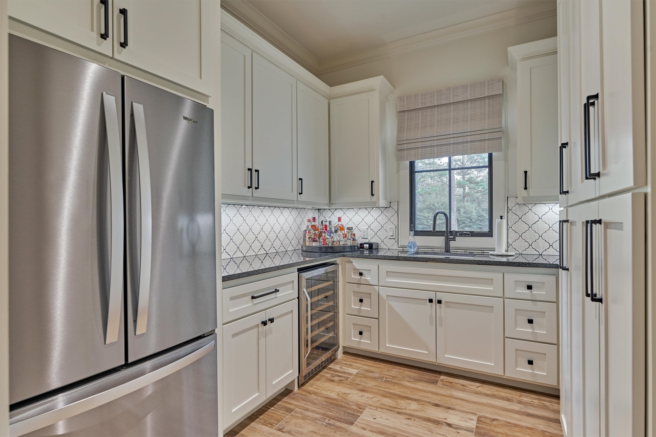 4469 Lily Bean Road Montgomery, TX 77316 - Photo 20 of 50 a kitchen with white cabinets stainless steel appliances and a window