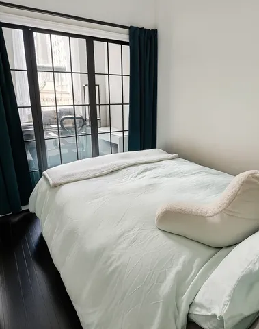 a bedroom with a bed and a large window