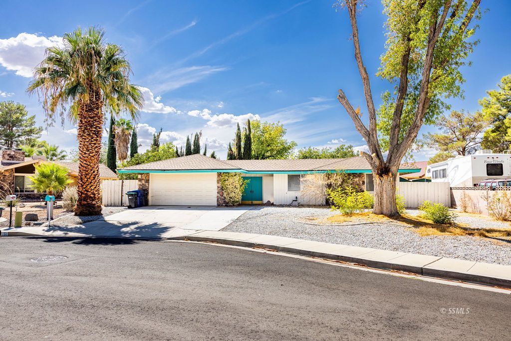 1243 Wayne Street Ridgecrest, CA 93555 - Photo 3 of 42 a front view of a house with a garden and tree