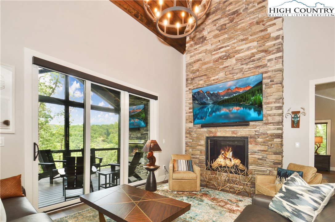 1736 Twin Rivers Drive Boone, NC 28607 - Photo 6 of 46 a living room with furniture a fireplace and a flat screen tv